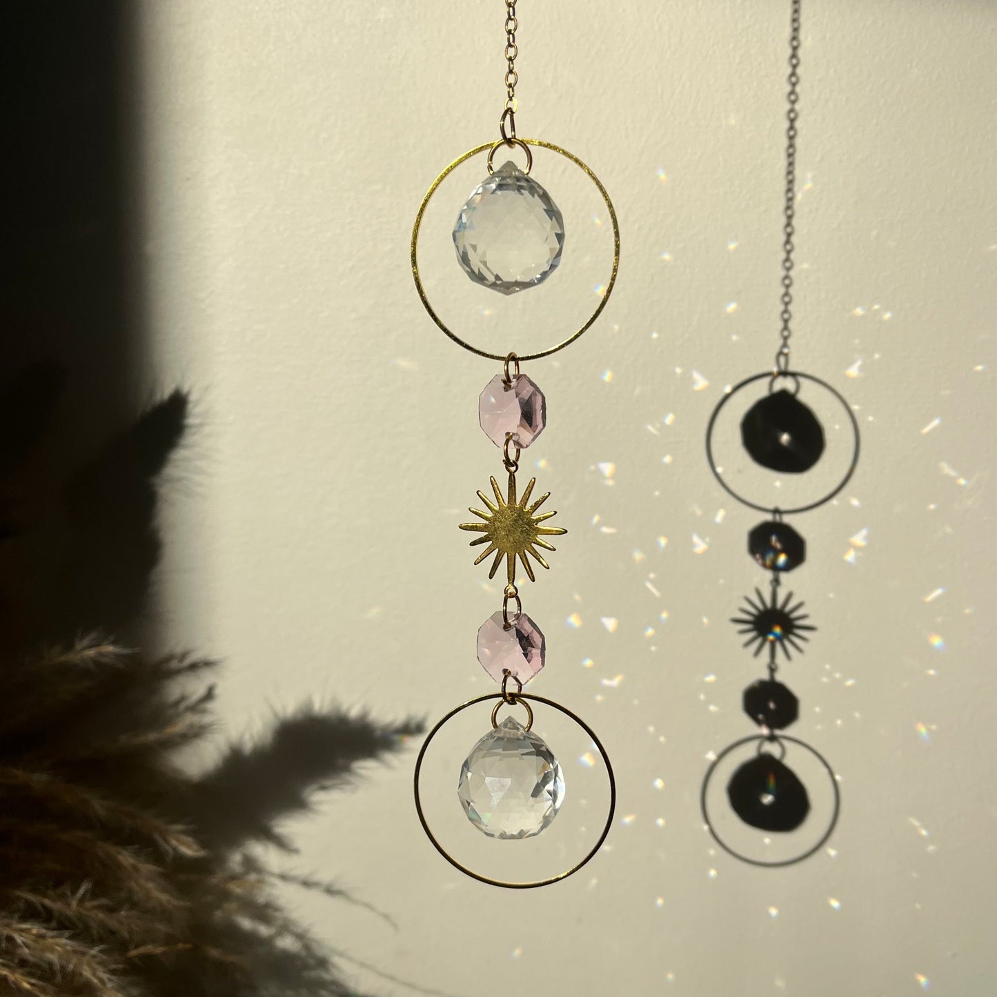 Decorative hanging with crystals and celestial elements on a neutral background