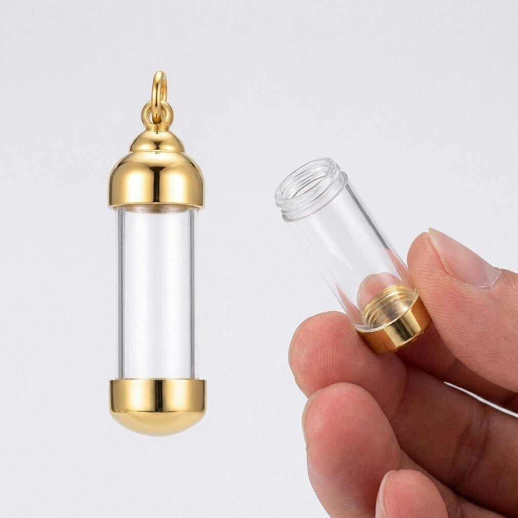 Gold and clear cylindrical container held by a hand on a white background