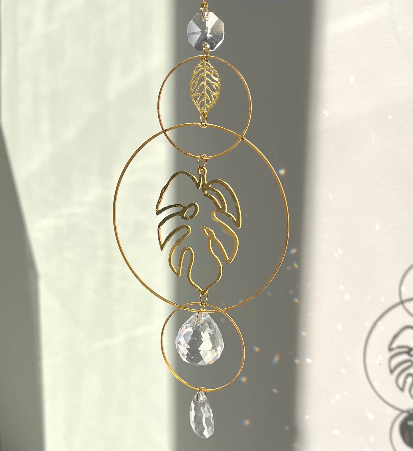 Decorative gold leaf ornament with crystal elements on a neutral background