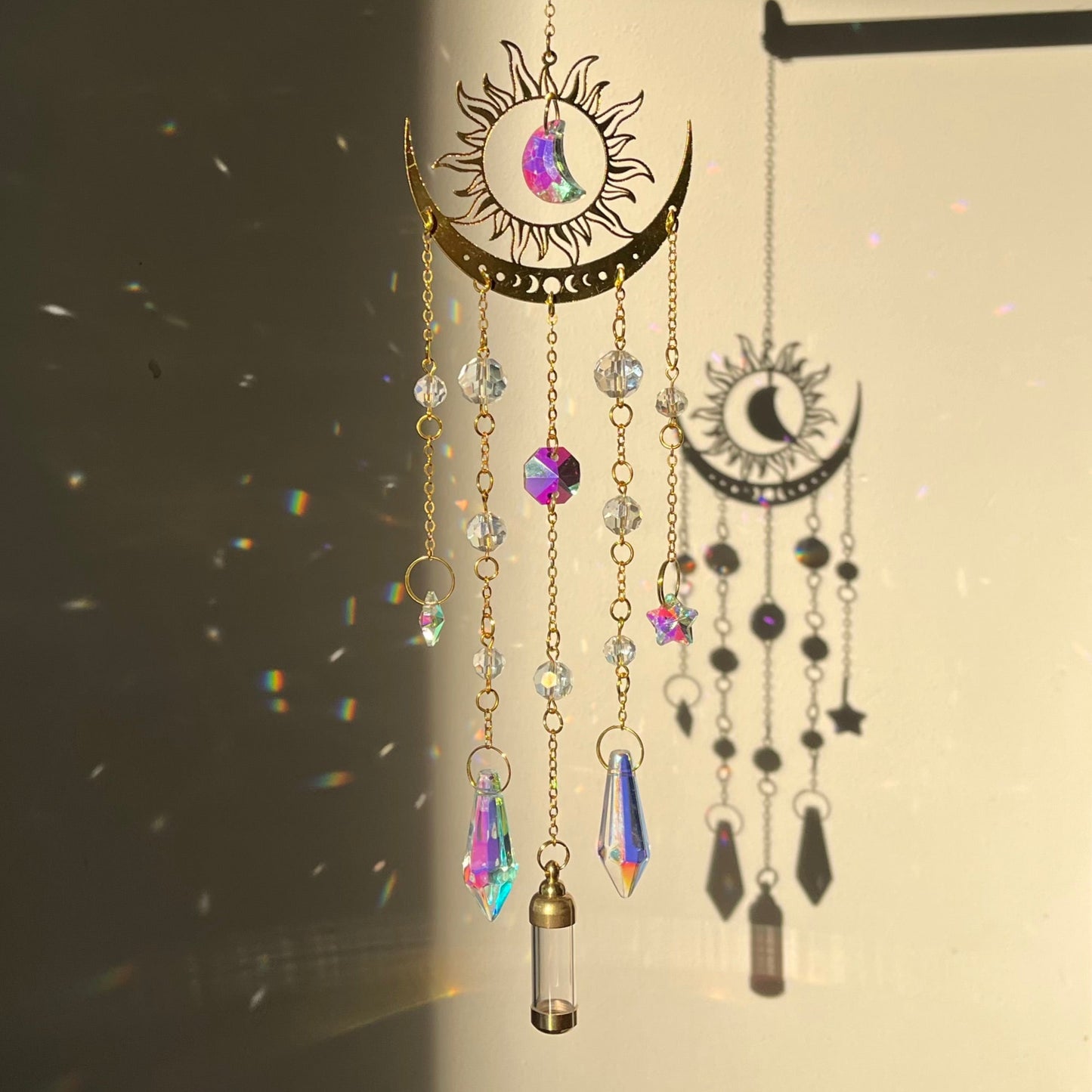 Decorative hanging ornament with crystals and celestial designs on a dark background