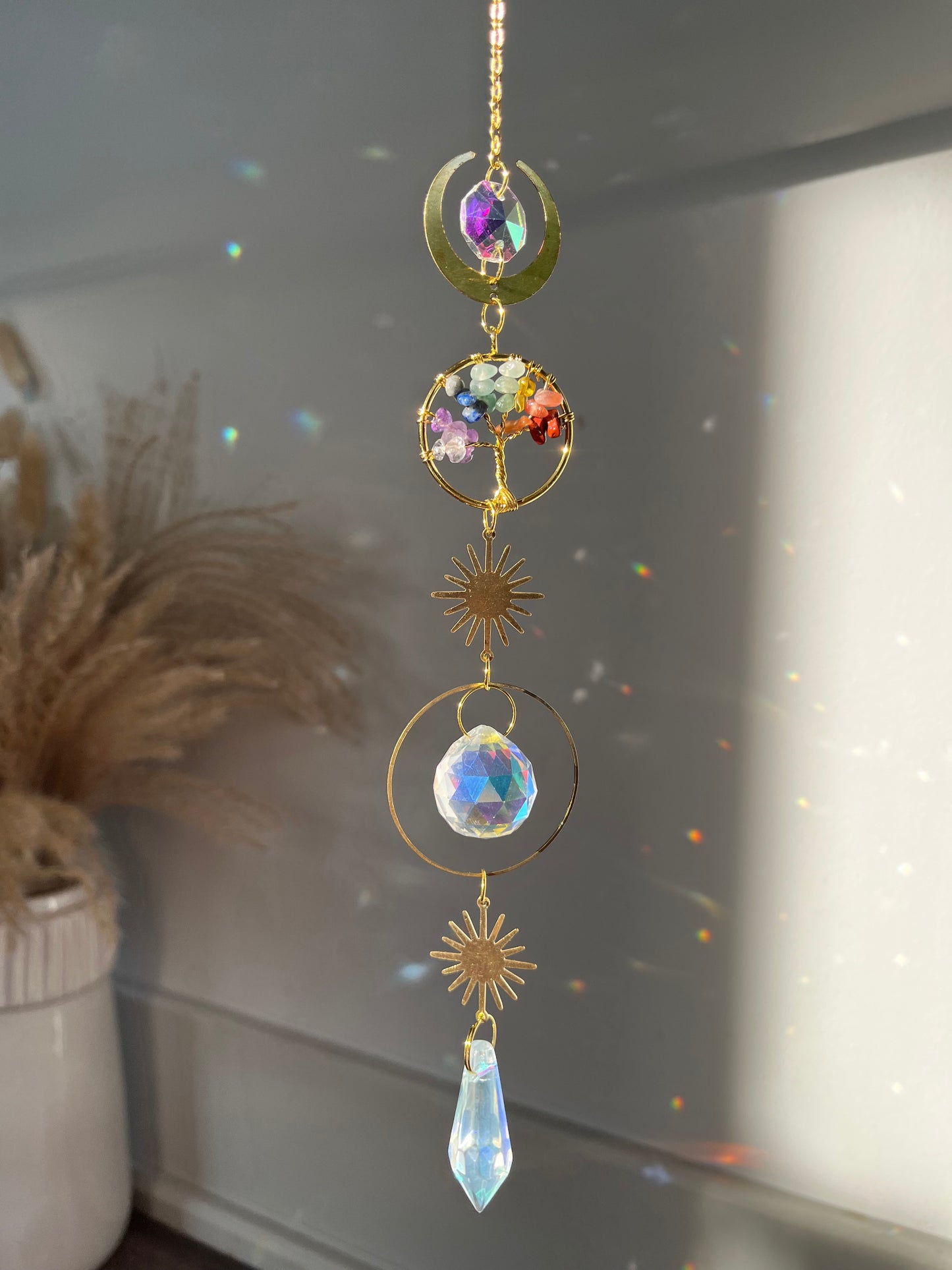 Decorative hanging with crystals and gold elements on a neutral background