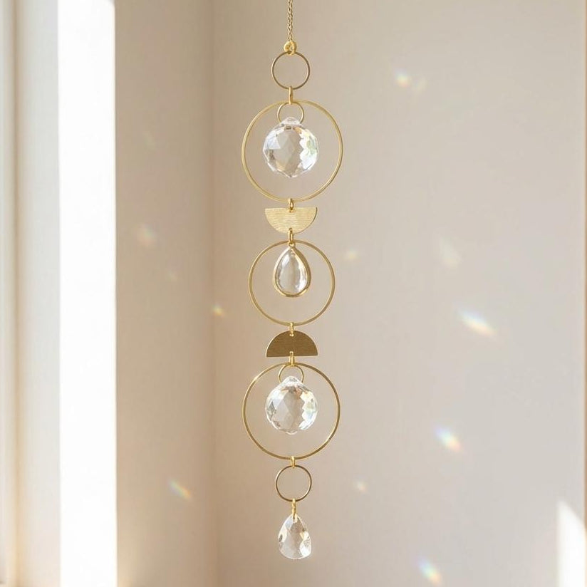 Decorative hanging crystal pendant on a neutral wall with a window in the background