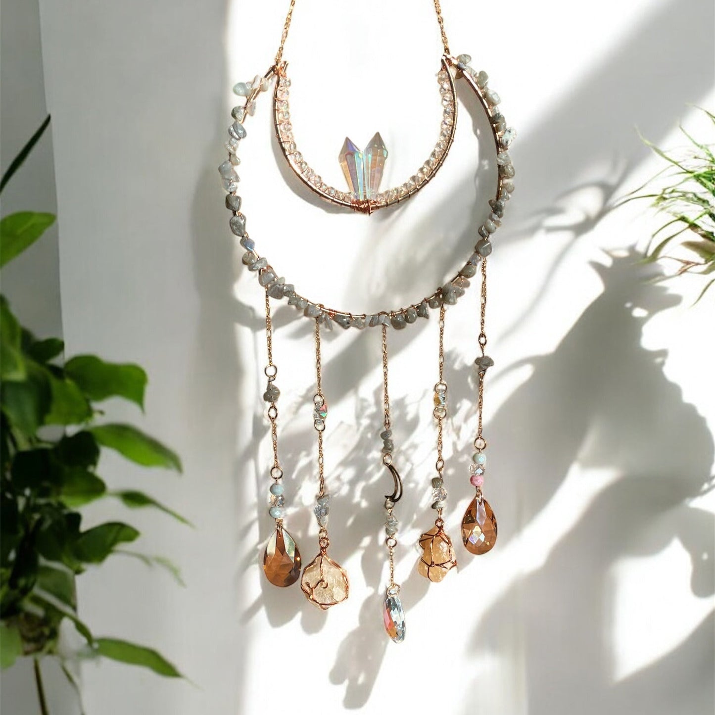 Decorative wall hanging with crystals and beads on a white wall