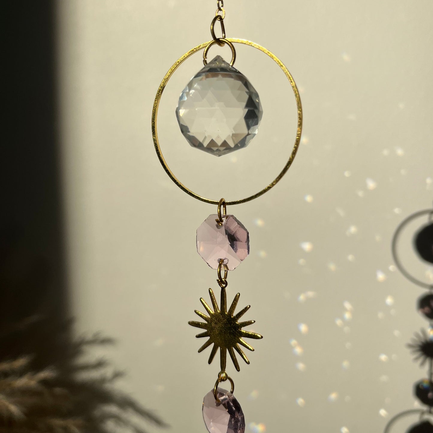 Decorative hanging crystal with gold accents on a neutral background