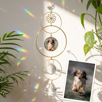 Decorative hanging ornament with a photo of a dog, surrounded by green leaves.