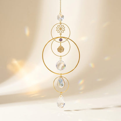 Decorative hanging ornament with gold loops and crystal beads on a beige background