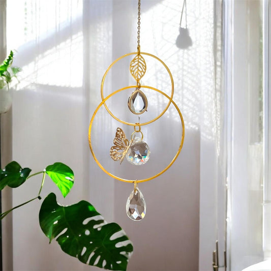 Glass suncatcher urn featuring a small ash compartment and a delicate butterfly symbol, displayed in sunlight.