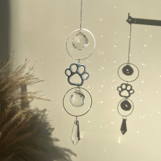 Decorative hanging with paw prints and crystals against a neutral background