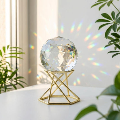 Crystal ball on a gold stand with plants in the background