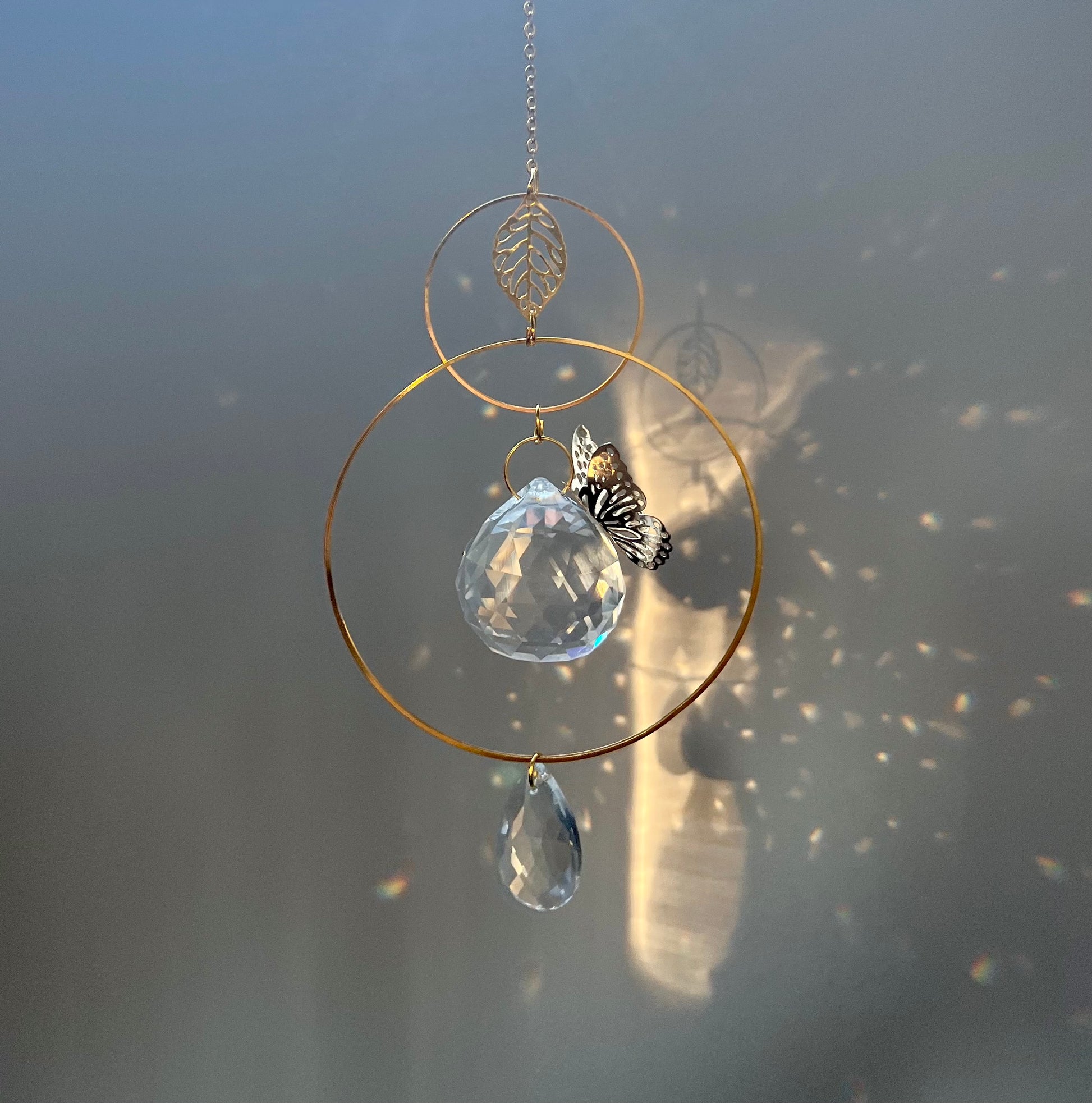 Decorative hanging ornament with crystal ball and butterfly on a blurred background