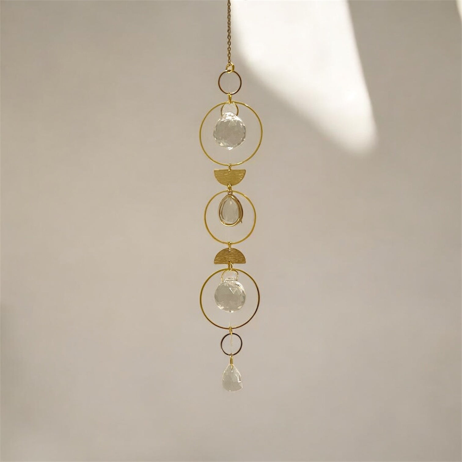 Decorative hanging chain with crystal-like beads on a neutral background