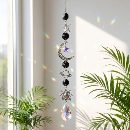 Decorative hanging crystal with celestial designs in a bright room with plants.