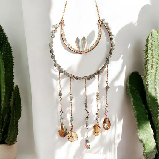 Decorative suncatcher with gemstones in front of a cactus plant