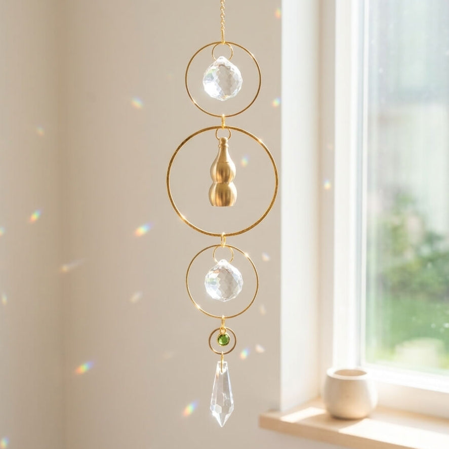 Decorative hanging crystal with gold accents in front of a window