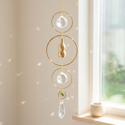 Decorative hanging crystal with gold accents in front of a window