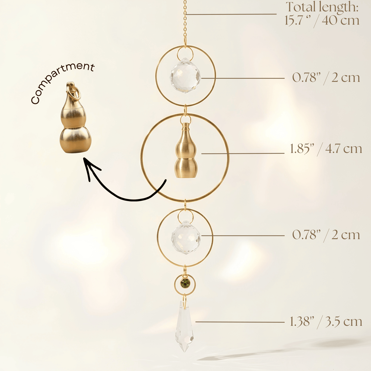 Gold-toned decorative suncatcher with a small gold compartment, clear crystal beads, and a teardrop crystal pendant, shown with measurement callouts and labels on a soft light background.