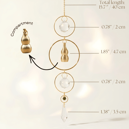 Gold-toned decorative suncatcher with a small gold compartment, clear crystal beads, and a teardrop crystal pendant, shown with measurement callouts and labels on a soft light background.