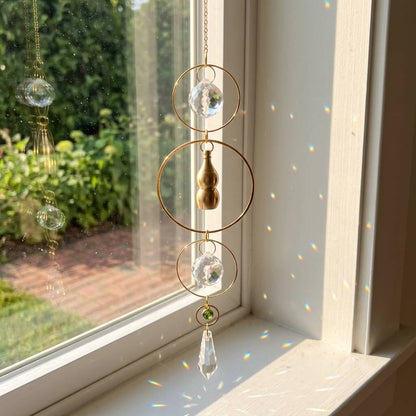Decorative hanging crystal ornament in front of a window with garden view