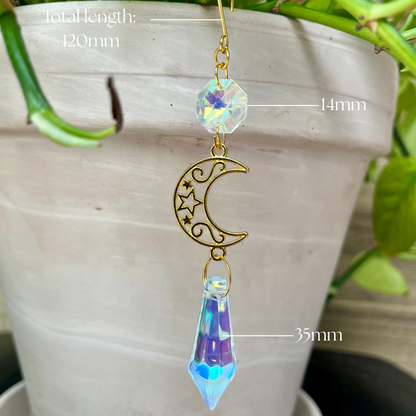 Decorative hanging charm with measurements in front of a potted plant