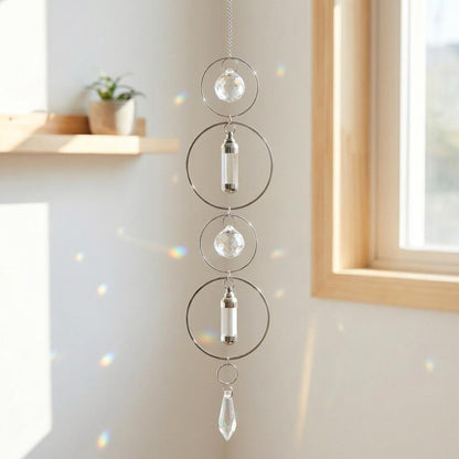 Crystal hanging decor with circular designs and clear beads in a room with a window.