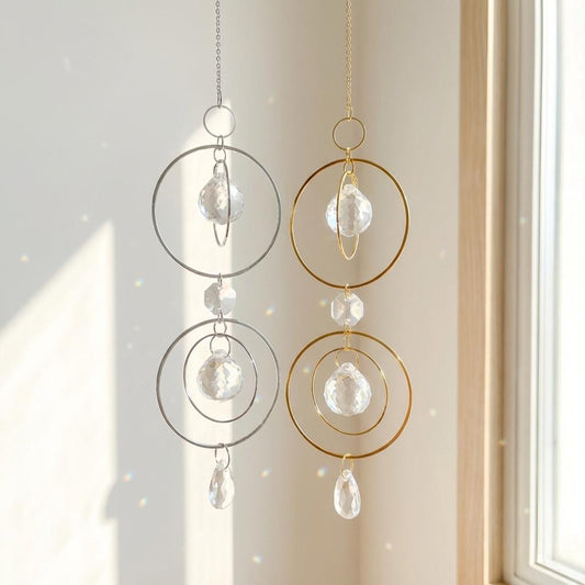 Decorative hanging crystal chimes with gold and silver loops on a neutral background