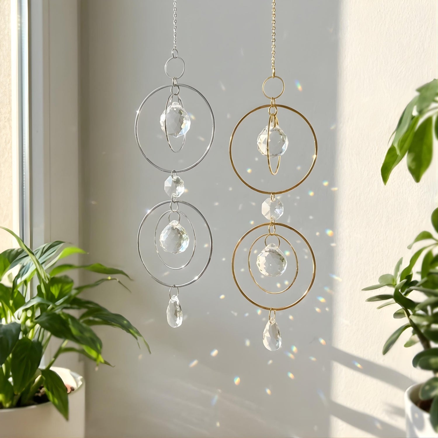 Crystal wind chimes hanging by a window with plants in the foreground