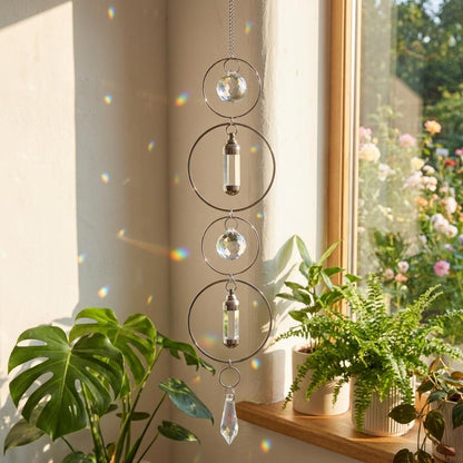 Decorative hanging crystal chime in front of a window with plants