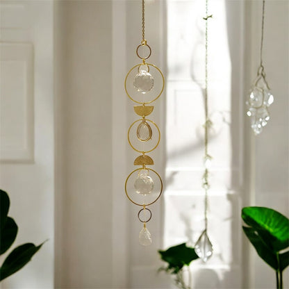 Decorative hanging chain with gold rings and clear crystals in a bright room.