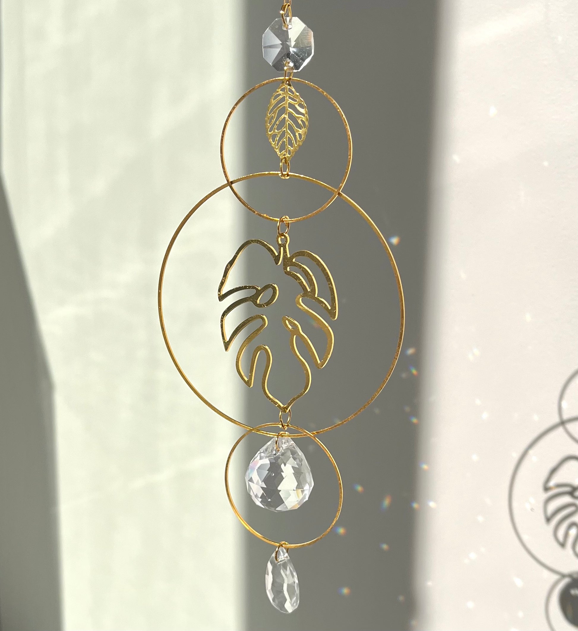 Decorative gold leaf ornament with crystal elements on a neutral background
