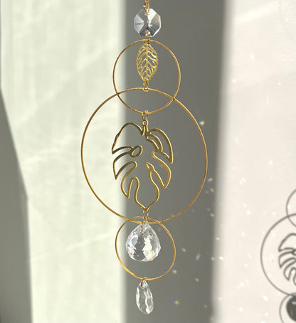 Decorative gold leaf ornament with crystal elements on a neutral background