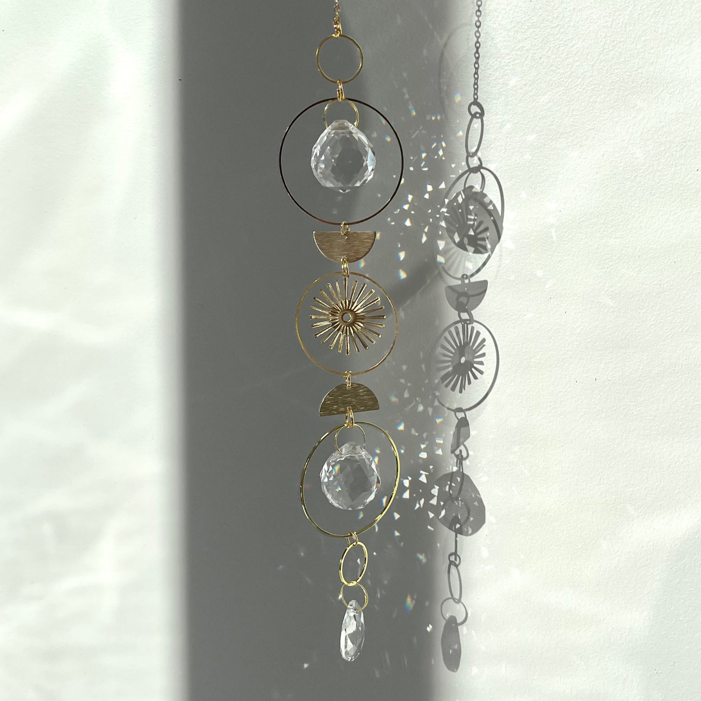 Decorative hanging with geometric shapes and crystals on a white background