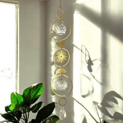 Decorative hanging ornament with gold and crystal elements on a light background