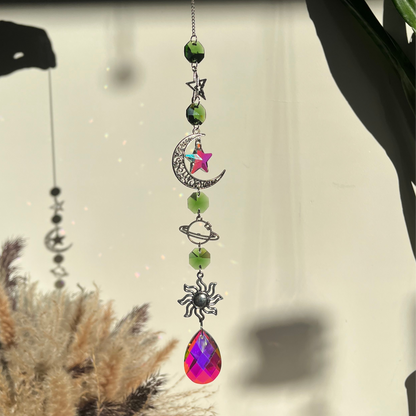 Decorative hanging ornament with celestial elements and a colorful teardrop pendant.