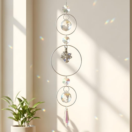Decorative hanging crystal mobile with a plant on a windowsill.