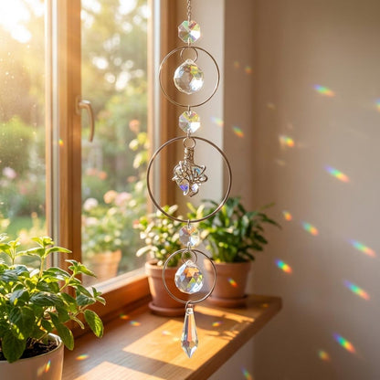 Crystal sun catcher hanging by a window with plants on a windowsill
