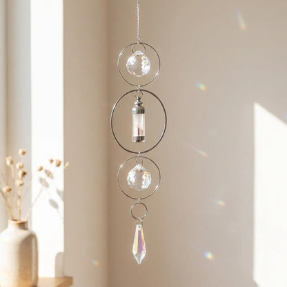 Decorative hanging crystal with a vase on a windowsill in a bright room