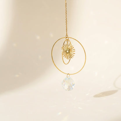 Gold necklace with a crystal pendant on a soft beige background