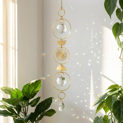 Decorative hanging crystal with gold accents in front of a light curtain