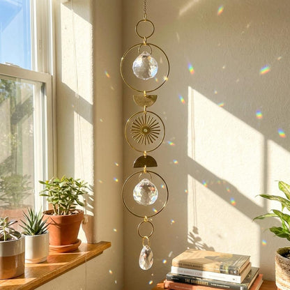 Decorative hanging crystal with sunburst designs in a sunlit room.