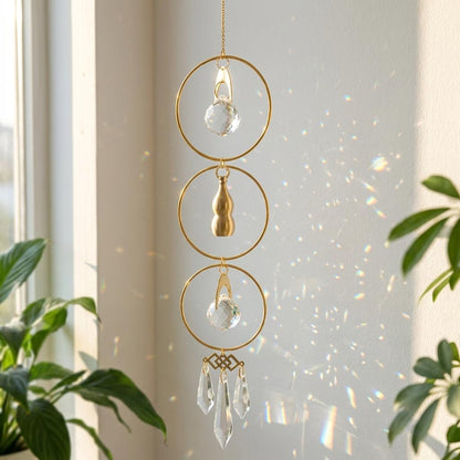 Decorative hanging crystal with gold loops and clear crystals on a light background