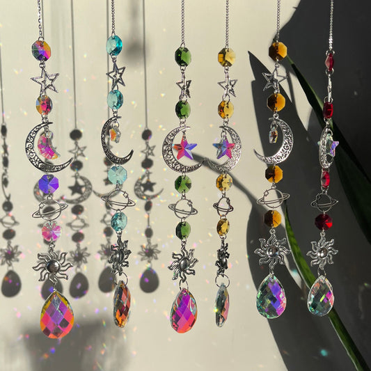 A series of decorative wind chimes with colorful gemstone pendants and silver elements, displayed against a light background.
