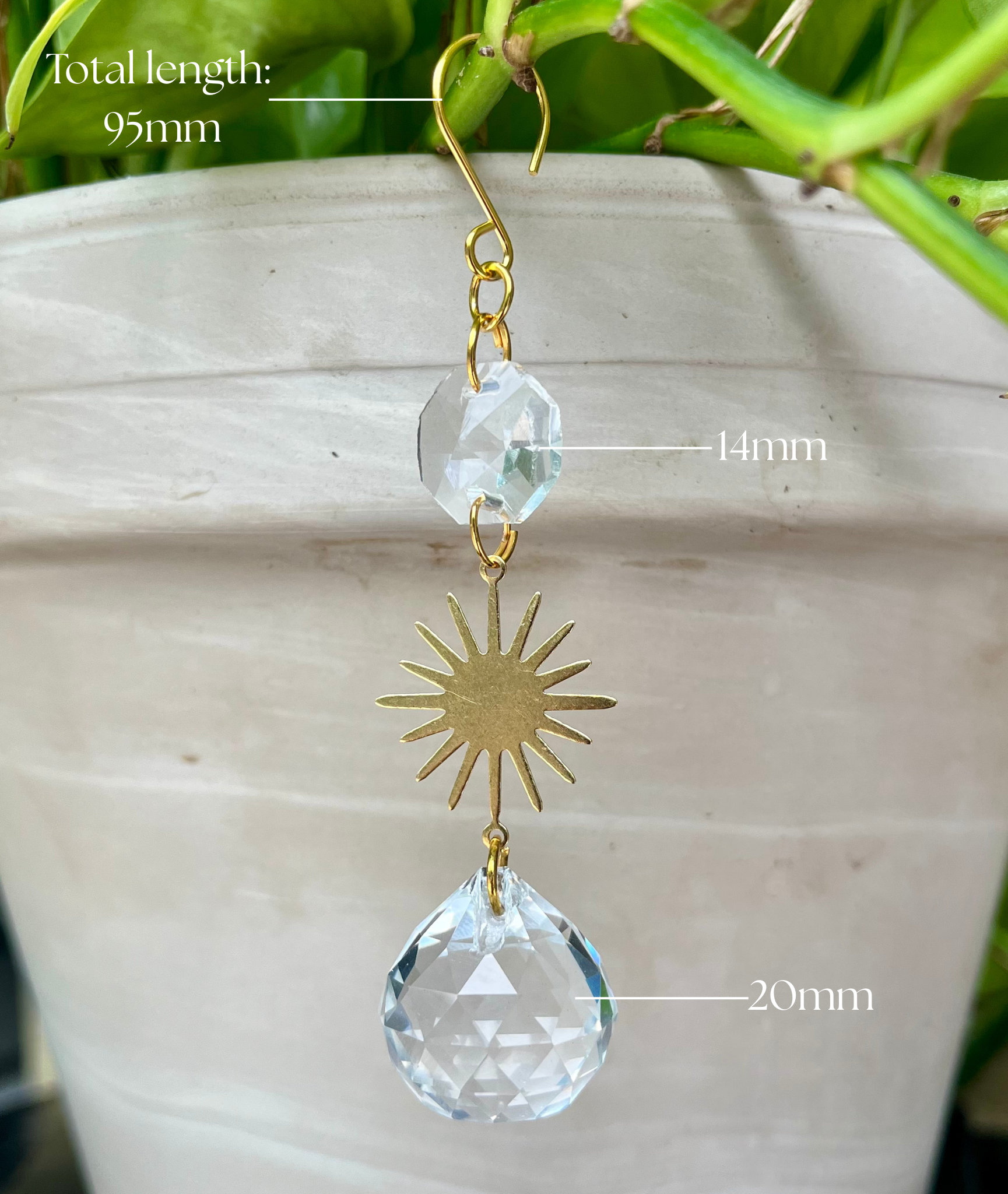 Crystal sun-shaped hanging ornament with measurements on a neutral background