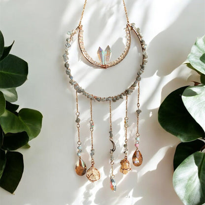Suncatcher with gemstones and crystals on a white background with green leaves