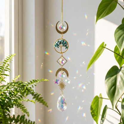 Decorative hanging crystal with rainbow effect in front of a window with plants.