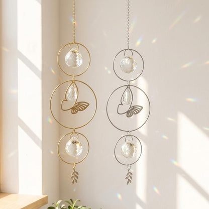 Decorative hanging ornaments with glass spheres and leaf designs on a light background.