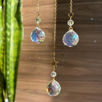 Pair of dangling earrings with crystal-like beads on a wooden surface.