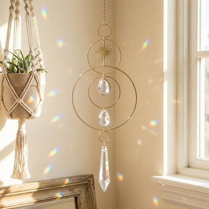 Decorative hanging crystal with macrame plant holder against a neutral wall.
