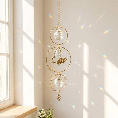 A gold butterfly suncatcher with delicate hanging crystals that scatter vibrant rainbow light across the room as sunlight passes through