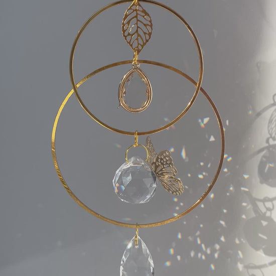 Memorial suncatcher urn with a small ash holder and a gentle butterfly symbolizing the soul’s journey, glowing in the light.