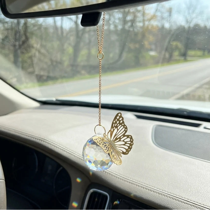 Butterfly-shaped car ornament hanging from a car's rearview mirror.